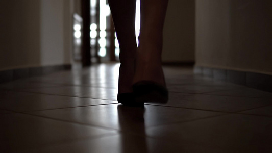 穿着高山鞋的黑走廊走着时装模特儿的脚影慢动作视频