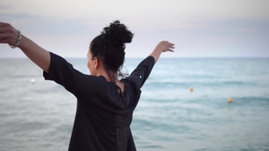妇女举起双手伸展在海滩上转过身去9秒视频