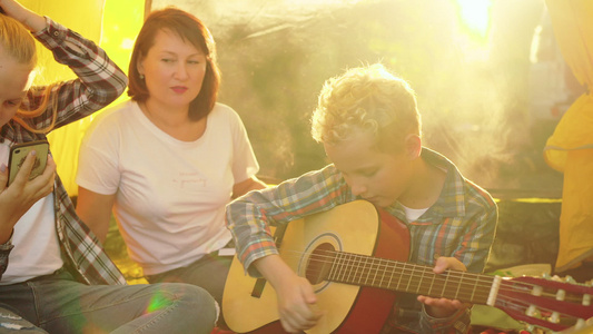 母亲与儿子和女儿在帐篷里享受吉他视频