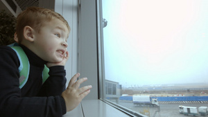 母亲和儿子在机场花时间看着窗外的窗户25秒视频