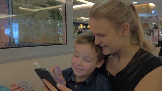 母亲和儿子用手机卡阅读器支付费用视频