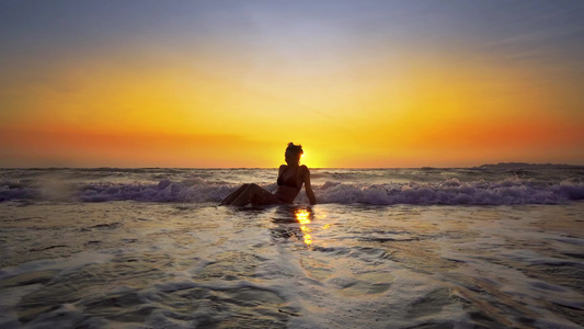 在热带海滩的日落时坐在海水中电影般的摇摆乐场上我非常视频