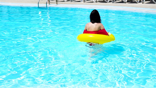 年轻美女在游泳池放松快乐女孩在豪华酒店的户外泳池中视频