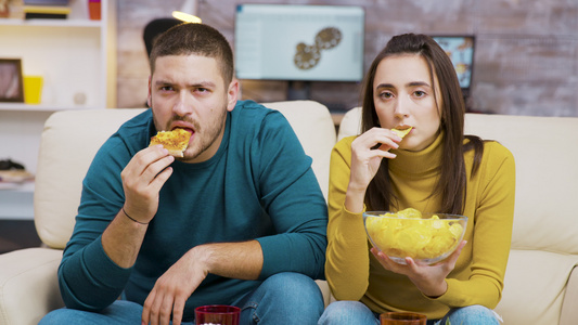 看着电视吃垃圾食品时吓着一对夫妇视频