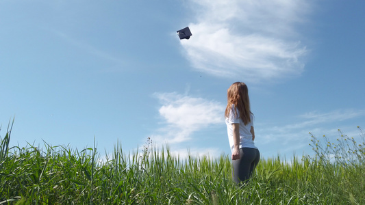光是毕业女孩就在一个绿色的绿地里蓝天空把帽子扔在空气视频