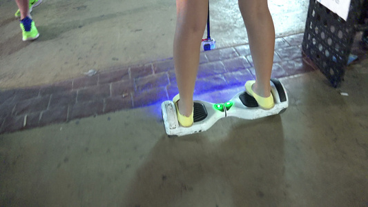 女孩在暗光线行道上使用悬浮板视频