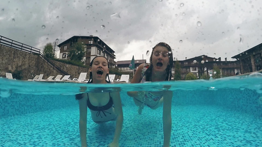 游泳池中的两个女孩Gopro圆顶半水下视图慢动作视频