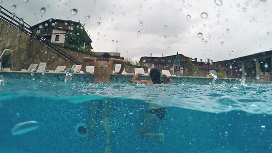 2个女孩游泳然后在雨天下离开泳池Gopro圆顶半水下视频