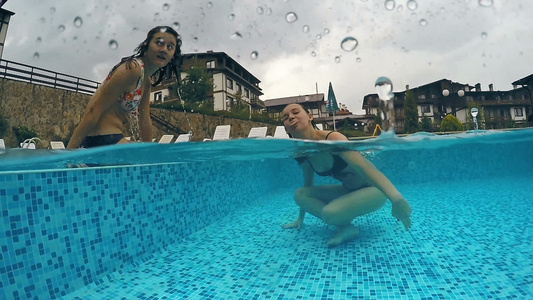 两个朋友在雨天在浅水池里玩耍微笑着对着镜头做鬼脸gopro视频