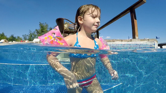 有臂带的小女孩享受户外热温泉水池慢动作视频