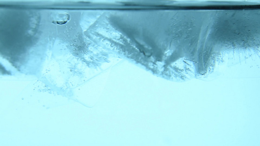 清冰的立方体在蓝水中漂浮紧闭视频