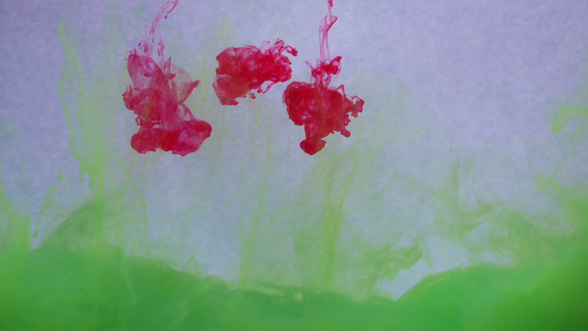水中的红色和绿色墨水创意慢动作在白色背景上视频