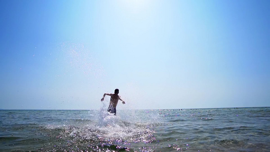 男性在海水中奔跑和跳跃电影Stadicam漫步拍摄视频