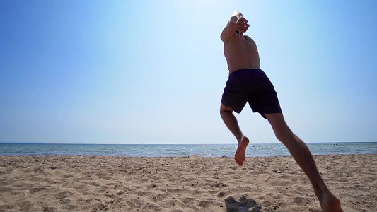 男性在海水中奔跑和跳跃电影Stadicam漫步拍摄视频