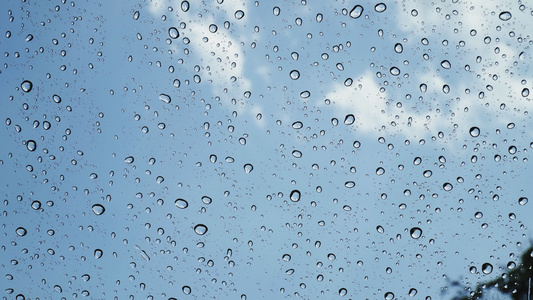 特写雨落在汽车的挡风玻璃上水滴在玻璃上雨天水在玻璃视频