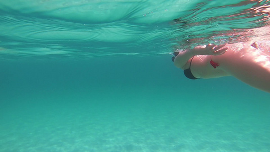 一位年轻美女在透明的蓝色水下游泳视频