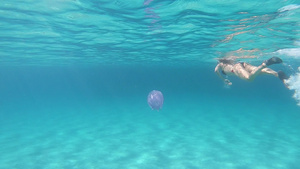 一位年轻美女在水下慢动作拍摄在透明的蓝色中游泳身上58秒视频