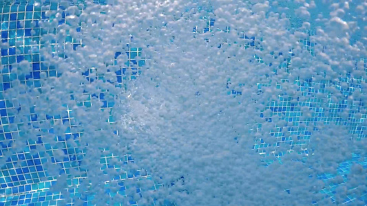 泳池中清蓝水中的空气泡泡水下喷射适合背景慢动视频