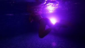 在LED灯背光的暗池中游泳女性的剪影11秒视频