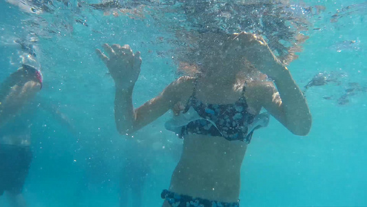 水下视图十几岁的女孩在游泳池里游泳的护目镜人们在透明视频