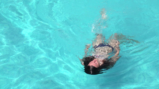 女孩在游泳池里游泳4K的空中射击视频
