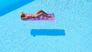 在大游泳池空气床垫上的年轻女子18秒视频