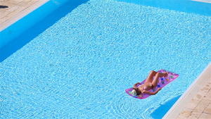 在大游泳池空气床垫上的年轻女子12秒视频