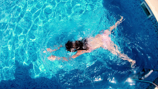 一个小女孩在豪华度假胜地潜水游泳池中视频