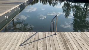 阳光明媚的一天在松树林的游泳池旁木甲板上栏杆的长长的14秒视频