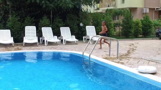 男孩在蓝游泳池中跑步跳跃慢动作视频