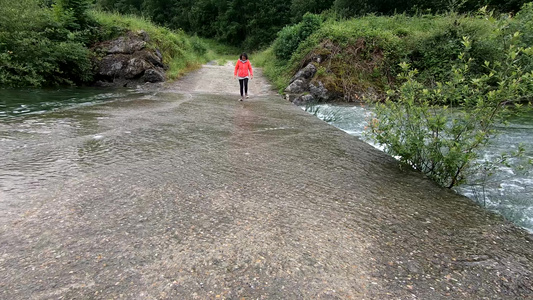 在比利牛斯山的Gabas漏油道大坝附近行走的妇女视频