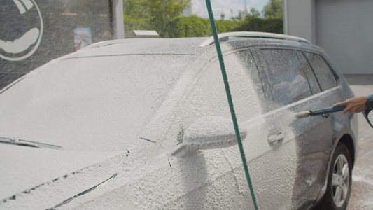 30岁的年轻妇女在自助洗车时洗家用汽车女性洗车时外面视频