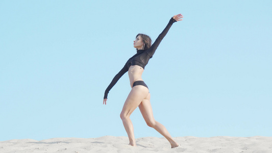 美丽的柔软女舞女舞蹈者在沙漠沙滩上表演视频