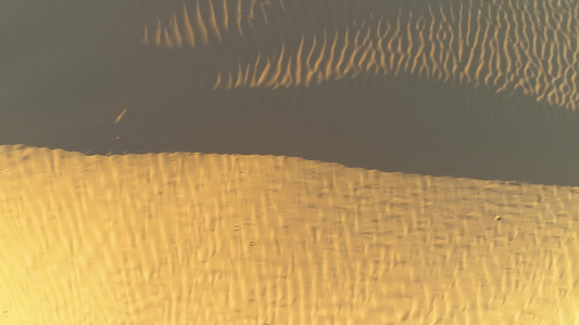 无人驾驶飞机在沙漠沙丘上空向左飞行空中垂直直射视频