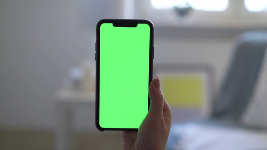 配有绿色屏幕显示铬的智能智能手机妇女手握并使用视频