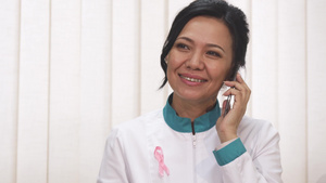 美丽的亚洲女医生在电话上聊天时笑得开心12秒视频
