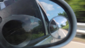 侧面镜子后方在一辆行驶的汽车中看到风景13秒视频