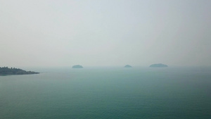 泰国海上的烟雾远处可见小岛天空笼罩着一层白烟小波浪16秒视频