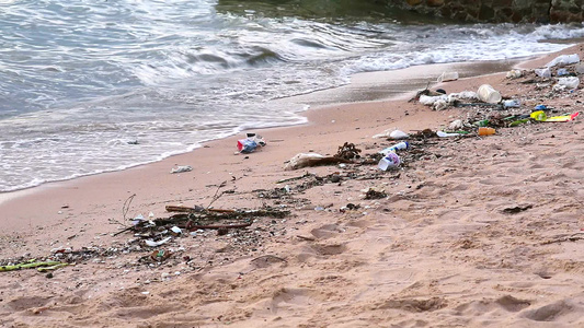 海面日落沙滩上留下泡沫和废物海浪将它们吹入海中1视频