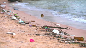 海边日落沙滩上有塑料和废物海浪将它们吹入海中13秒视频