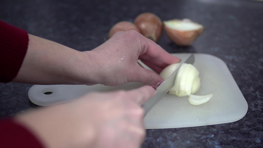 手握尖利刀在厨房板上切洋葱视频