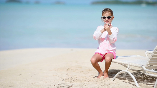 快乐的小女孩手里拿着玩具飞机在白色的沙滩上孩子在沙滩视频