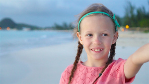 可爱的小女孩在热带白沙滩拍自拍慢动作15秒视频