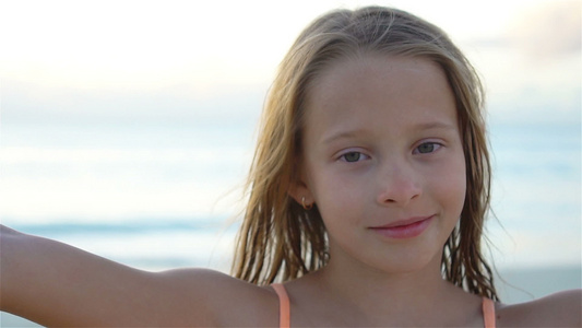 可爱的小女孩在热带白沙滩拍自拍慢动作视频