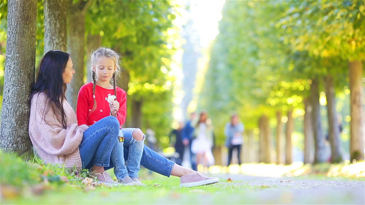 妈妈和小女孩的家庭在秋天年轻妈妈和小孩享受温暖的秋天视频