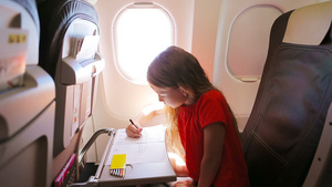 可爱的小女孩乘飞机坐在飞机窗边10秒视频