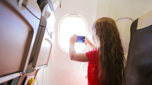 乘飞机旅行的可爱的小女孩坐在窗边孩子坐在飞机窗口附近8秒视频