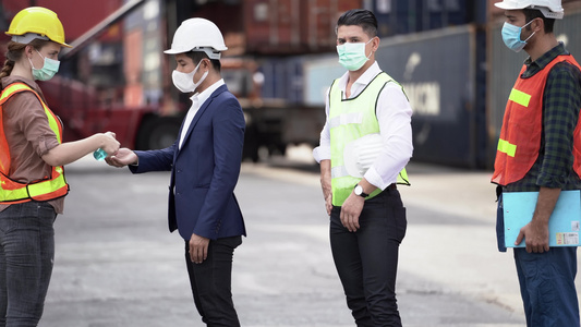工厂女工戴着医用口罩和安全服使用酒精凝胶进行手部清洁视频