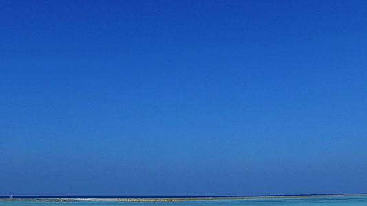 珊瑚礁附近蓝海和白色沙滩背景的平缓海滨海滩航行宽阔视频