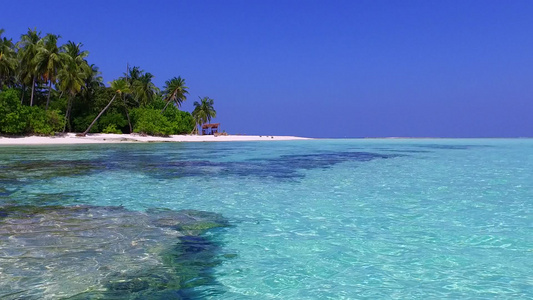 以蓝海和沙巴附近白沙滩背景白沙滩航行的宁静岛屿海滩视频